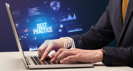 Businessman working on laptop with BEST PRACTICE inscription, new business concept