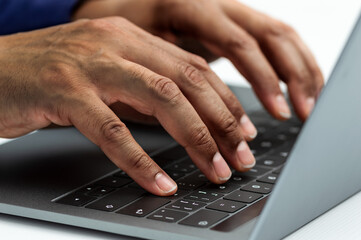 Closeup shot of a unrecognizable business person typing on a laptop keyboard