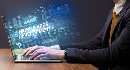 Businessman working on laptop with MOBILE APPS DEVELOPMENT inscription, cyber technology concept