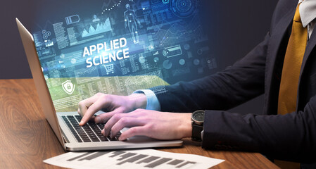 Businessman working on laptop with APPLIED SCIENCE inscription, cyber technology concept