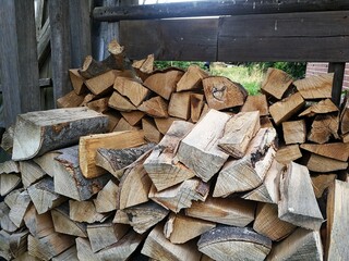Firewood, logs stacked for drying in a weather protection