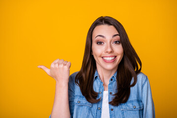 Portrait of childish excited girl point thumb finger copyspace direct way incredible sales ads promo wear good look clothes isolated over vivid color background