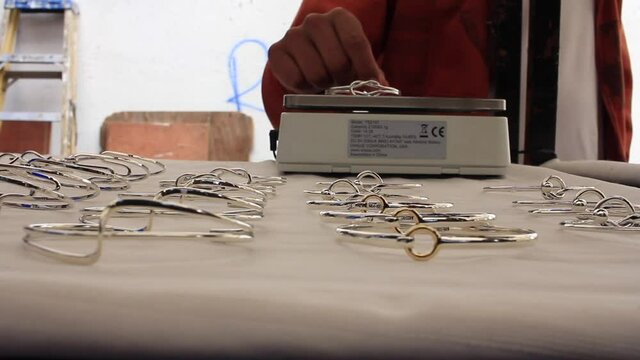 a person is weighing a silver bracelet in a traditional market in Taxco Guerrero