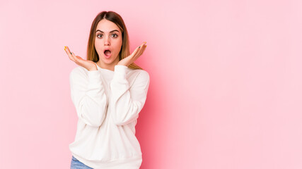 Young caucasian woman isolated on pink background surprised and shocked.