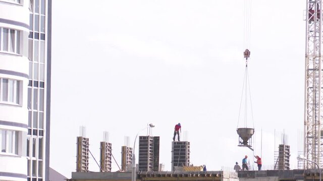Builders on the construction site erect a monolithic building, reinforced concrete and the implementation of a variety of architectural forms.