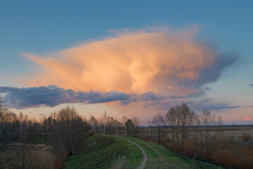 red cloud cloud over the forest by the lake at sunset
