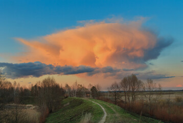 Fototapeta na wymiar red cloud cloud over the forest by the lake at sunset