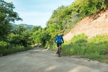 Fototapeta premium A mountain biker with a landscape of rocks and mountains