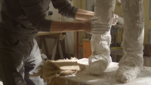 Artist working on plaster sculpture in beautiful workshop