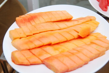 fresh papaya slices served on white plates