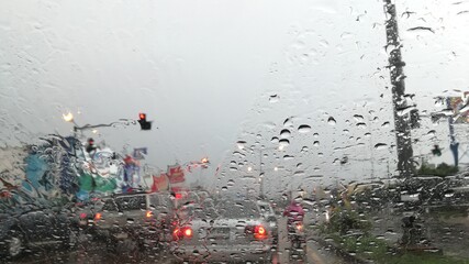 Rain fell on the car while parking, caught on traffic lights.