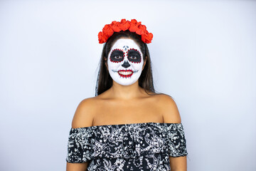 Woman wearing day of the dead costume over isolated white background smiling looking at the camera