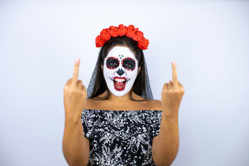 Woman wearing day of the dead costume over isolated white background showing middle finger doing...