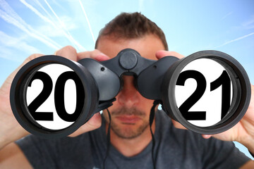 Mann mit Fernglas schaut ins Jahr 2021