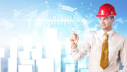 Handsome businessman with helmet drawing EMPLOYEE BENEFITS inscription, contruction business concept