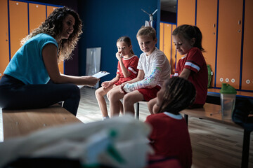 The coach talking to her little soccer players