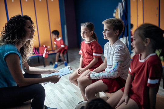 The coach gives the tasks to her little soccer players - Powered by Adobe