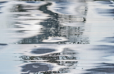 Wet asphalt road surface at autumn evening time.