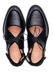 Beautiful elegant women's summer lace-up sandals made of black crocodile leather with low heels, isolated on a white background with shadow. Summer women's shoes. Top view.