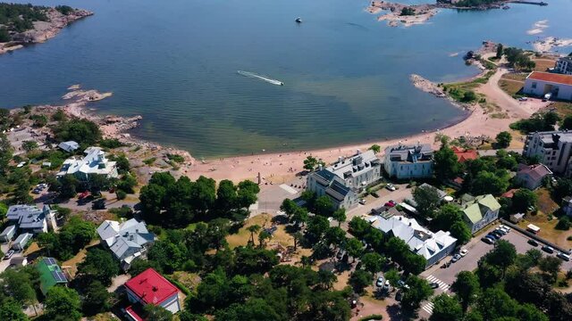 Aerial view of a boat arriving at the Downtown boulevard beach, on a sunny day in Krogars, Hanko, Finland - Dolly, drone shot