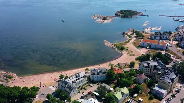 Aerial view away from the boulevard beach, revealing the East harbor and the Gulf of Finland, warm, sunny, summer day in Krogars, Hanko city, South Uusimaa, Suomi - tilt up, drone shot