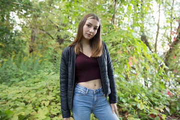 Portrait of a beautiful brunette outdoors on a green forest background.