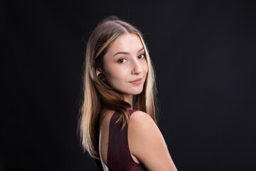 Naklejka premium Beautiful brunette in an elegant dress on a black background.