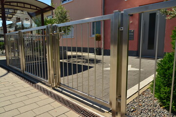 Edelstahl-Gartentor vor einem Einfamilienhaus