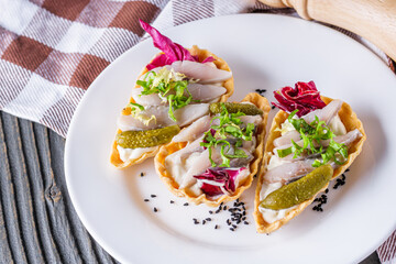 delicious snack tartlets on rustic wooden background