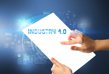 Hand holdig futuristic tablet with INDUSTRY 4.0 inscription, new technology concept