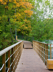 Fototapeta premium Boardwalk across the lake in autumn park