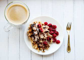 Sweet Homemade Berry Belgian Waffle with chocolate syrup and sugar powder and coffee