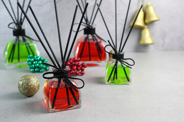 Fototapeta na wymiar colorful nice scent aroma reed diffuser glass bottles are displayed on the grey table with background of cement wall during merry christmas and happy new year party celebration festival winter season