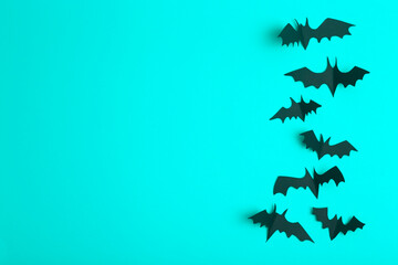 Halloween background. Black bats cut from paper on a blue background. Halloween decor and decorations for the holiday, copy space.