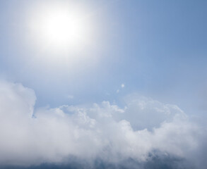 Fototapeta na wymiar sparkle sun above a dense cumulus clouds, natural outdoor background