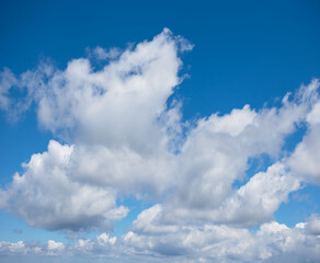 Naklejka na ściany i meble beautiful fluffy cumulus clouds on a blue sky background