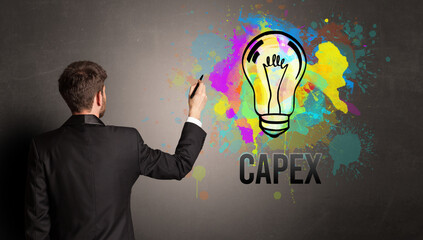 businessman drawing colorful light bulb with CAPEX inscription on textured concrete wall, new business idea concept