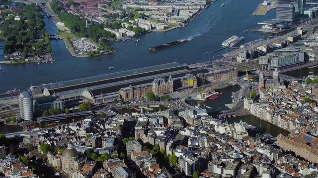 Aerial view of the IJ and the Amsterdam Centraal Station in Netherlands. Many ferries and cargo ships. 