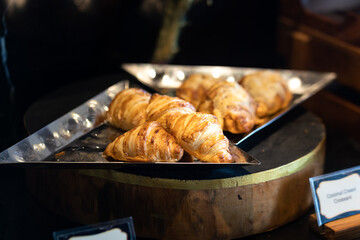 Toast croissant or puff pie bakery are displayed on wooden table, ready to serve on premium breakfast food line. Close-up and selective focus a some part of the object.
