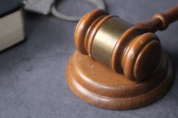 Obraz premium gavel, handcuff and book on table, close up 