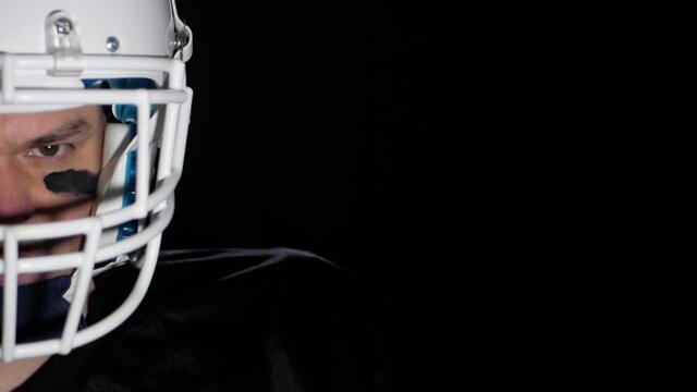 dark angry american football player isolated on black CLOSE UP SLOW MOTION