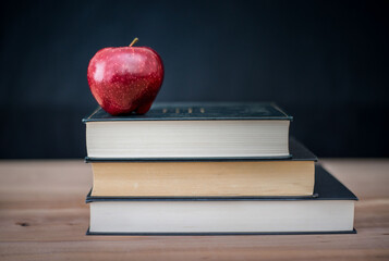 Red apple on black writing-books.   Autumn theme. Back to school.

