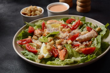 Caesar Salad with grilled chicken, Cheese and Croutons with lettuce, on plate.  Grilled chicken breasts and fresh vegetables in plate. 