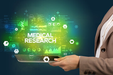 Close-up of a touchscreen with MEDICAL RESEARCH inscription, medical concept