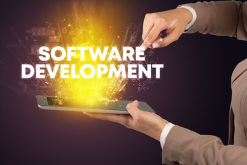 Close-up of a touchscreen with SOFTWARE DEVELOPMENT inscription, innovative technology concept