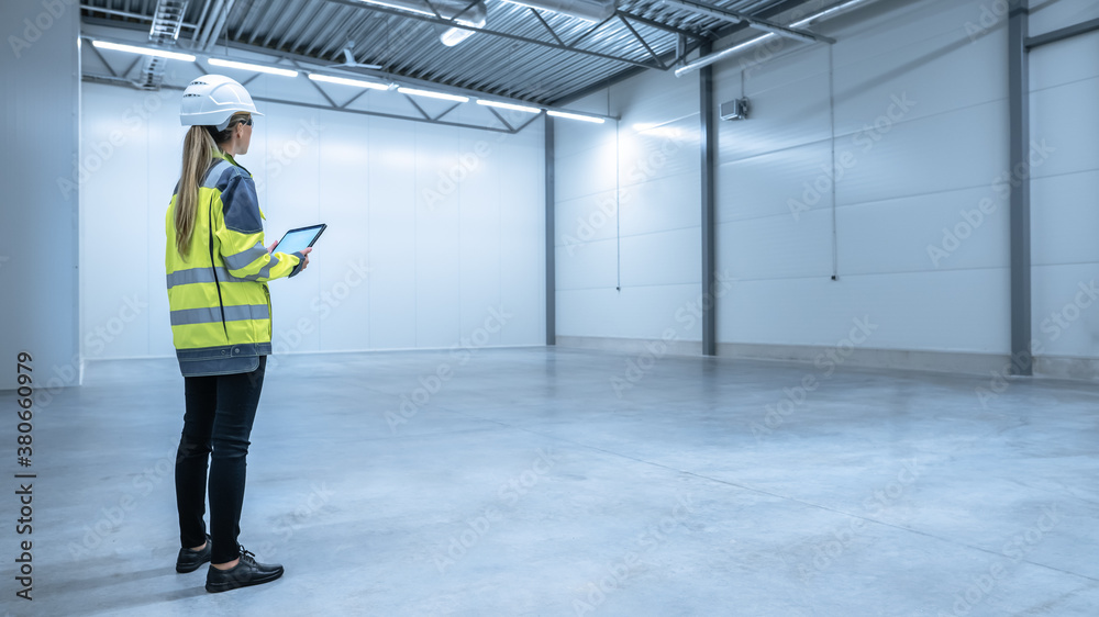 Poster Industry 4.0 Modern Warehouse: Female Engineer in Empty Warehouse Uses Digital Tablet Computer with Augmented Reality Software for Future Factory or Warehouse Layout. Concept Shot of Augmented Reality