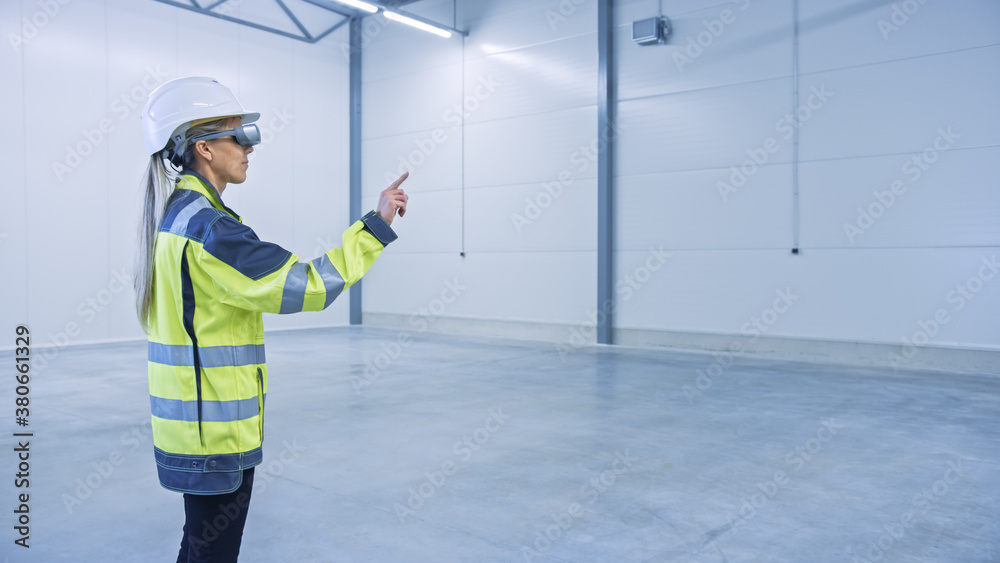 Poster Industry 4.0 Modern Factory: Female Engineer in Empty Warehouse Wearing Augmented Reality Headset and Working in Mixed Reality Software with Gestures. Great Mock-up Template for VFX Special Effects.