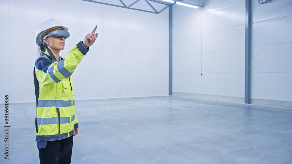Poster Industry 4.0 Modern Factory: Female Engineer in Empty Warehouse Wearing Augmented Reality Headset Uses Mixed Reality Software and Gestures. Great Mock-up Template for VFX Special Effects and Graphics.