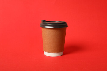 Takeaway paper coffee cup on red background