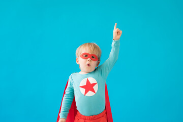 Portrait of superhero child against blue background © Igor Yaruta